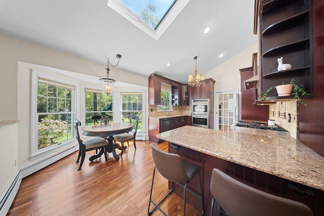 kitchen featuring an inviting chandelier, open shelves, decorative backsplash, light wood-style flooring, and appliances with stainless steel finishes