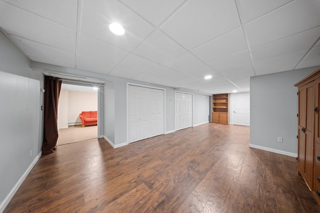 finished basement with baseboards, recessed lighting, dark wood finished floors, and baseboard heating
