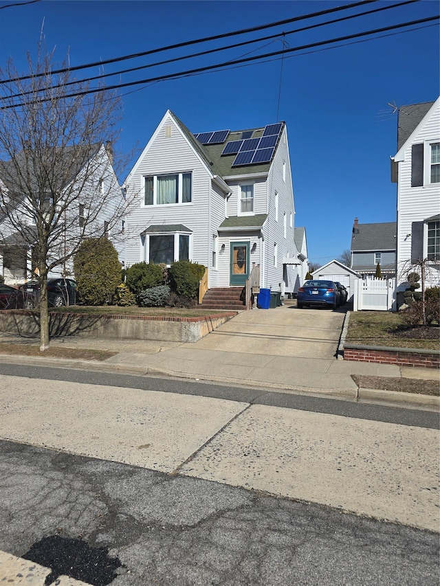 view of front of property featuring driveway and roof mounted solar panels