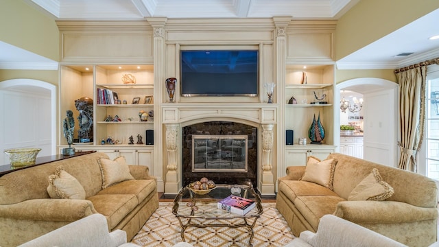 living room featuring built in shelves, a high end fireplace, and ornamental molding