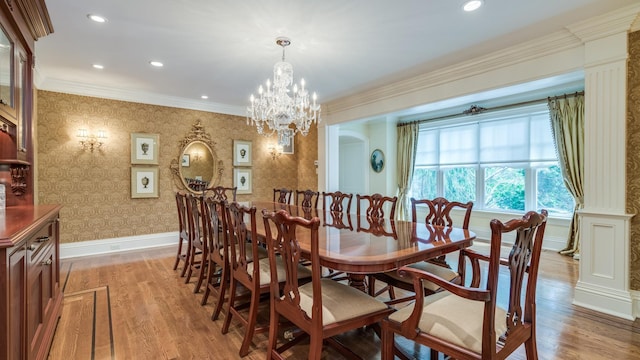 dining room featuring crown molding, light wood-style flooring, baseboards, and wallpapered walls