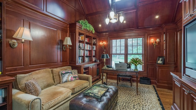 office area featuring built in features, a notable chandelier, wood walls, wood finished floors, and coffered ceiling