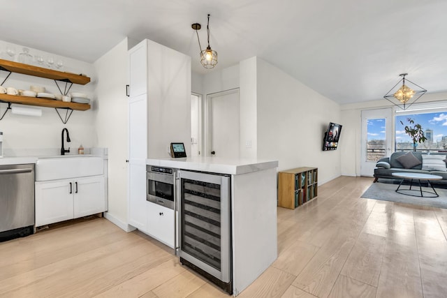 4705 Henry Hudson Pkwy W Unit 7G, Bronx, NY 10471 - kitchen featuring beverage cooler, stainless steel appliances, a sink, light countertops, and light wood-type flooring