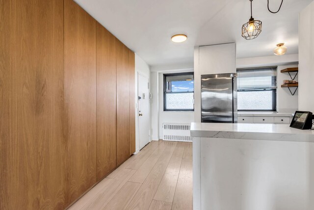 4705 Henry Hudson Pkwy W Unit 7G, Bronx, NY 10471 - kitchen with a healthy amount of sunlight, light wood-type flooring, stainless steel refrigerator, and radiator