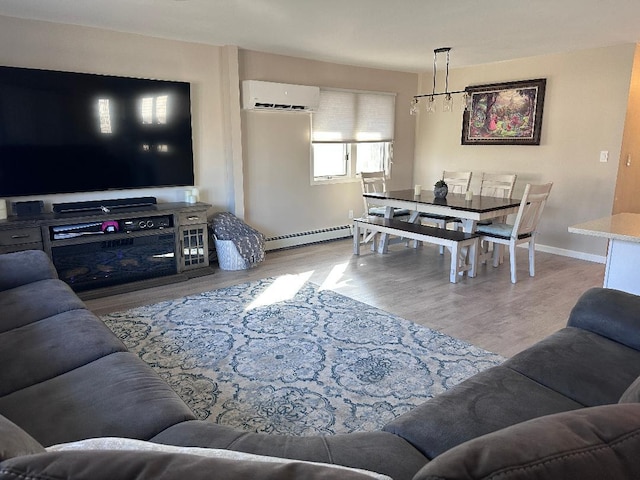 living area featuring a wall mounted AC, wood finished floors, baseboards, and a baseboard radiator