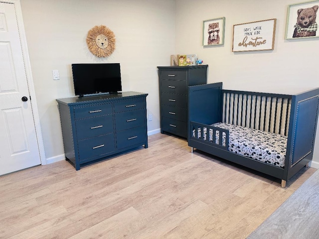 bedroom featuring light wood-style flooring and baseboards