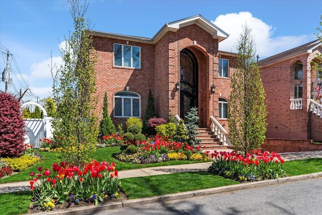 view of front of property with brick siding and fence