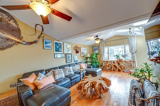 living area with lofted ceiling, hardwood / wood-style flooring, and a ceiling fan