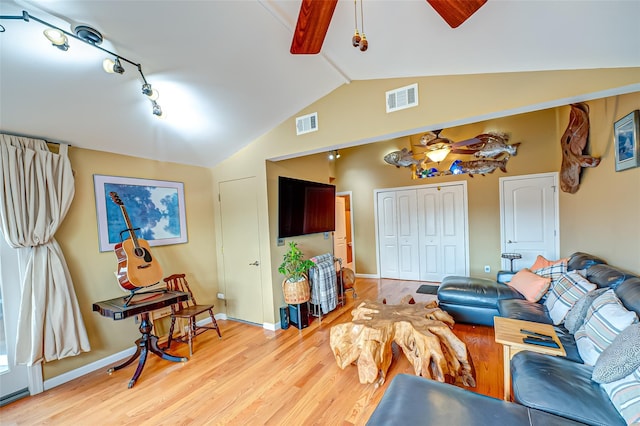 living area featuring lofted ceiling, visible vents, ceiling fan, and light wood-style flooring