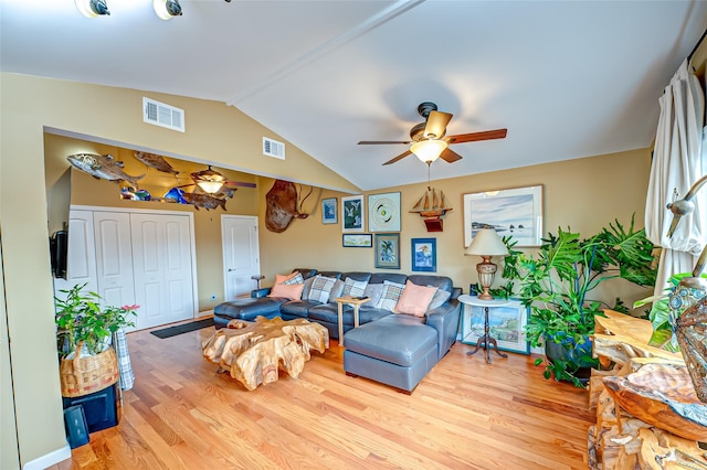 living area featuring lofted ceiling, wood finished floors, and visible vents