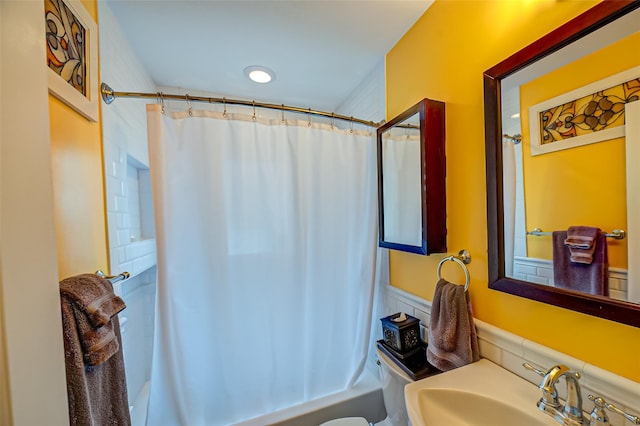 full bathroom featuring toilet, shower / bath combo, and a sink