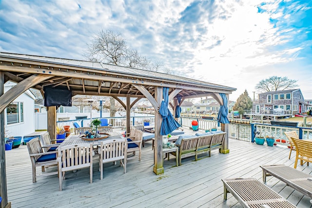 dock area featuring outdoor dining space, a wooden deck, and a gazebo