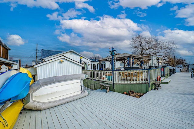 dock area with a gazebo, a wooden deck, and a residential view