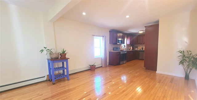 kitchen featuring a baseboard radiator, light countertops, appliances with stainless steel finishes, backsplash, and light wood finished floors