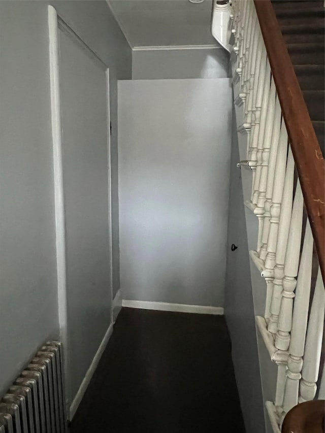 staircase with baseboards and radiator heating unit