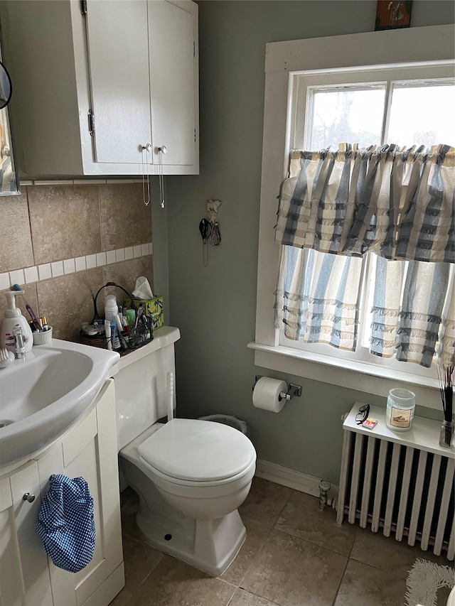 half bath featuring tile walls, radiator, toilet, tile patterned flooring, and baseboards