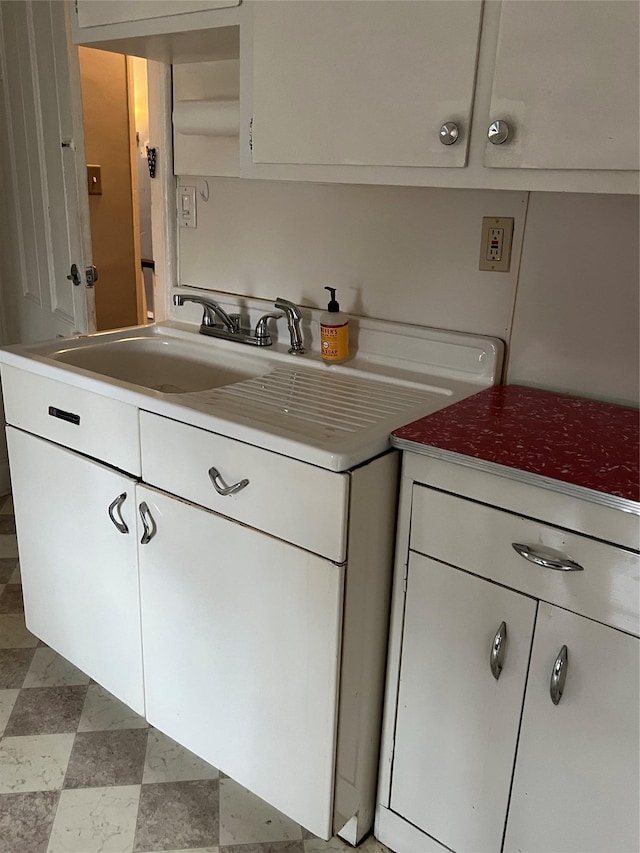 kitchen featuring light floors, white cabinetry, and light countertops