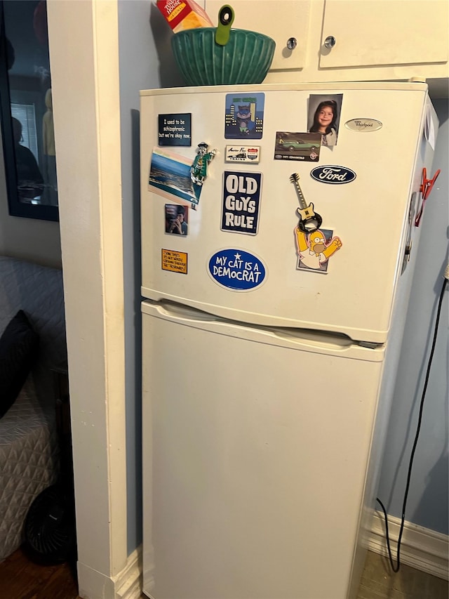 room details with freestanding refrigerator, baseboards, and wood finished floors