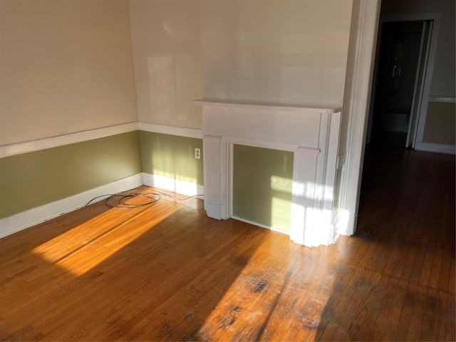 unfurnished living room with a fireplace, baseboards, and hardwood / wood-style floors