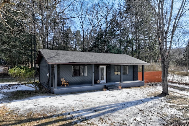 view of front facade with roof with shingles and a porch