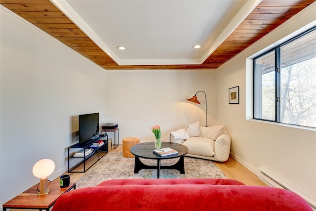 living room with recessed lighting, a baseboard heating unit, baseboards, and wood finished floors