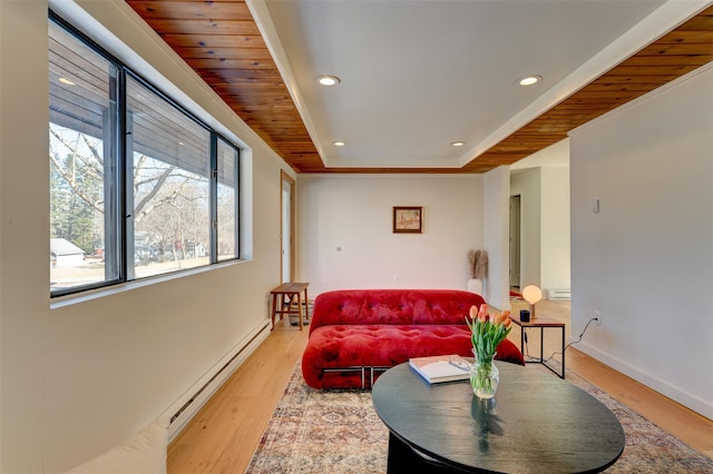 living room with baseboards, a tray ceiling, light wood-style flooring, recessed lighting, and baseboard heating
