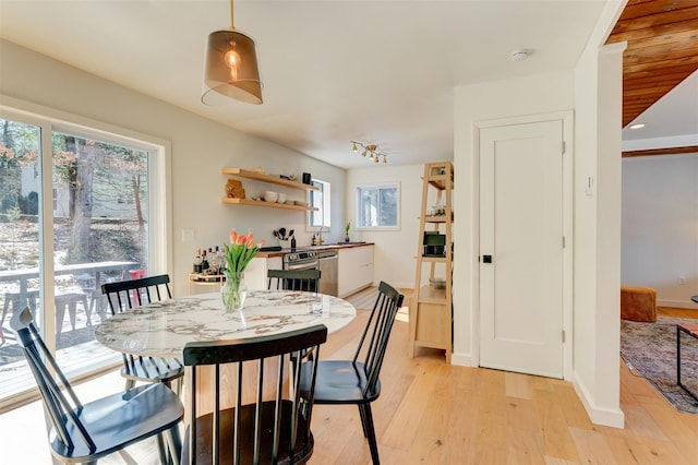 dining area with baseboards and light wood-style floors