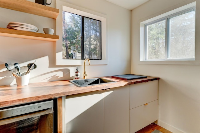 kitchen with a sink, beverage cooler, butcher block countertops, white cabinets, and open shelves