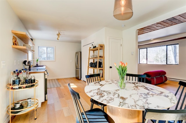 dining area with light wood finished floors and baseboards