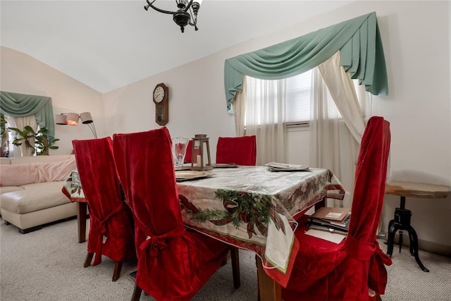 carpeted dining area with lofted ceiling