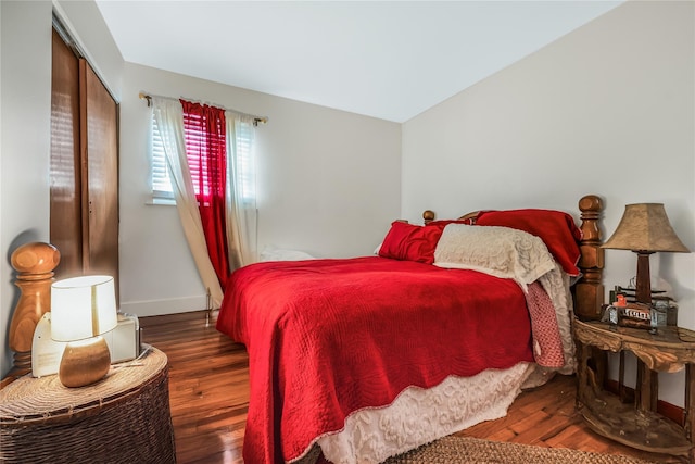 bedroom featuring a closet, baseboards, and wood finished floors