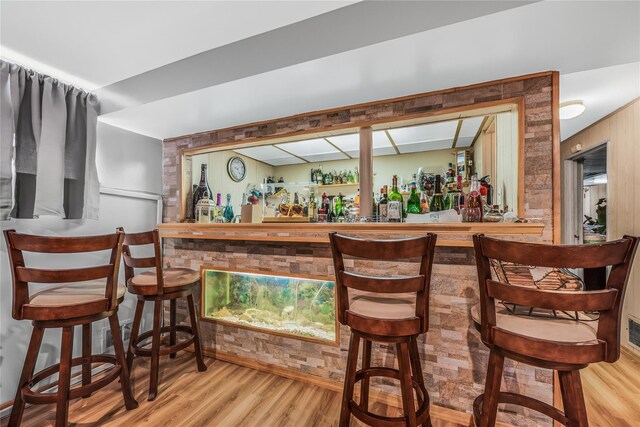 bar featuring a bar and wood finished floors