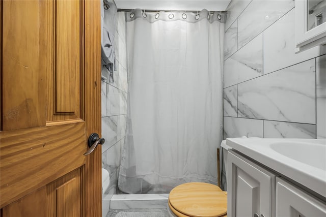 bathroom with toilet, a shower with curtain, tile walls, and vanity