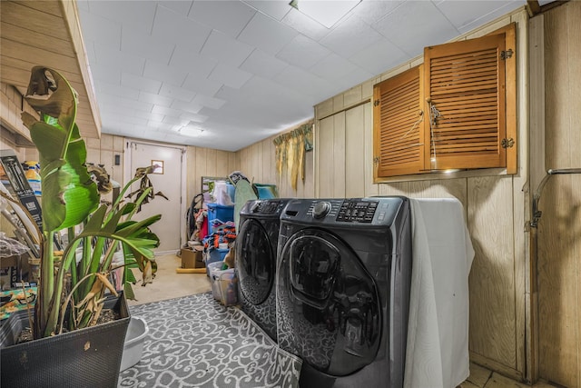 clothes washing area with cabinet space and wood walls