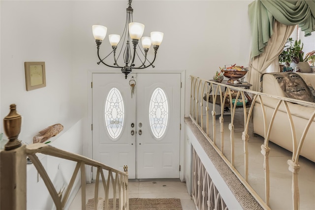 foyer entrance featuring french doors, light tile patterned flooring, and a notable chandelier