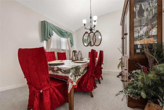 dining area with a chandelier, carpet, lofted ceiling, and baseboards