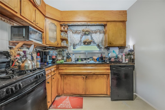 kitchen featuring baseboards, glass insert cabinets, brown cabinets, black appliances, and a sink