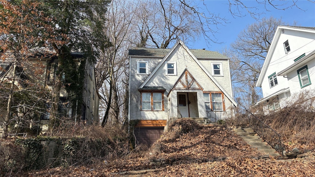 view of front of house featuring a garage and a shingled roof