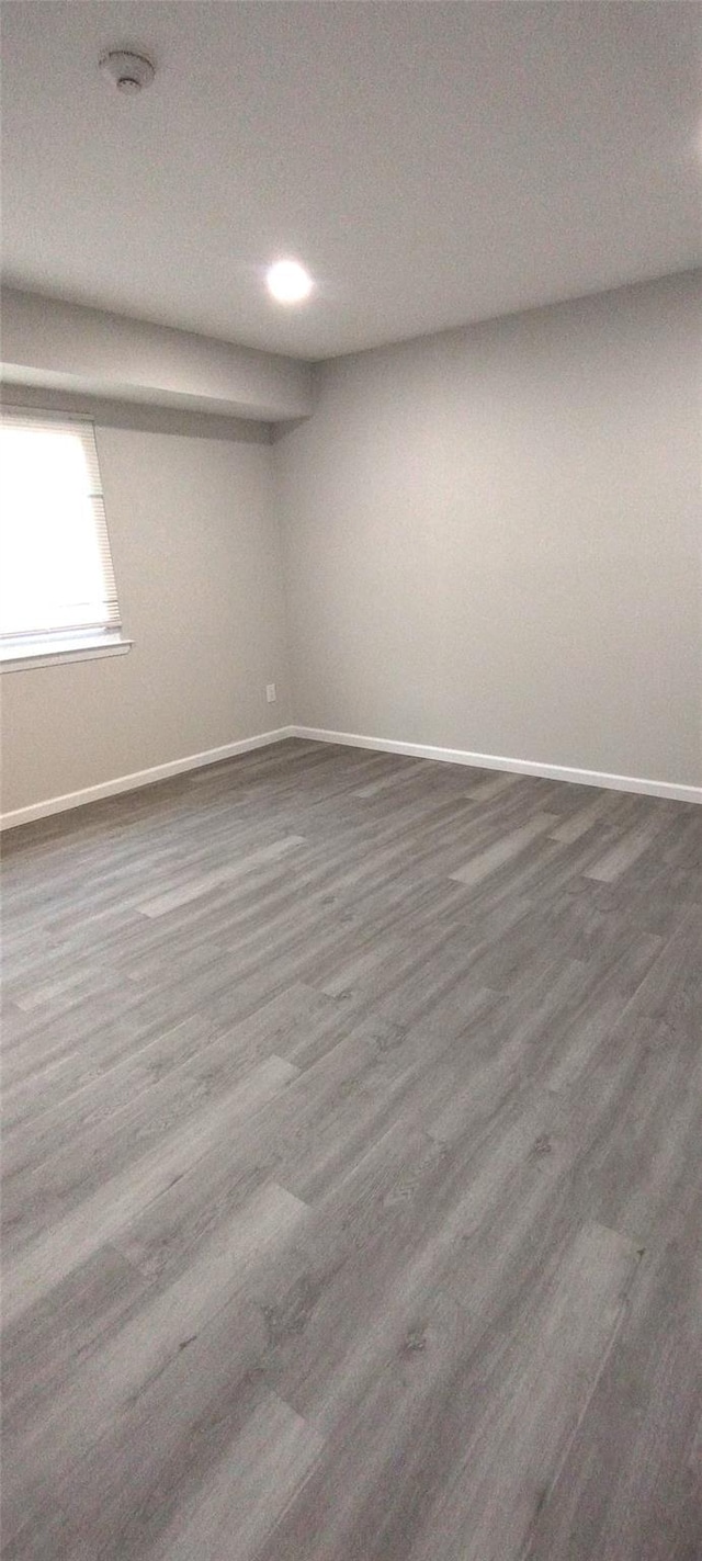 spare room with dark wood-type flooring and baseboards