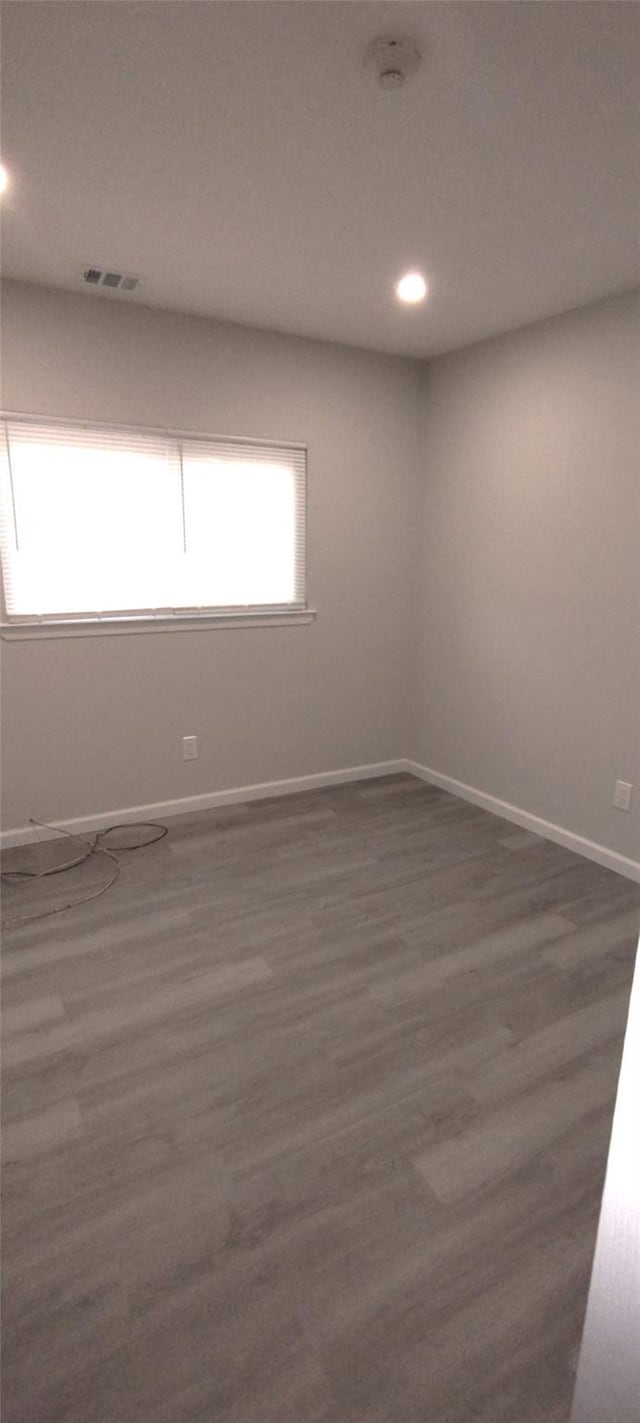 spare room featuring dark wood-style flooring, recessed lighting, visible vents, and baseboards