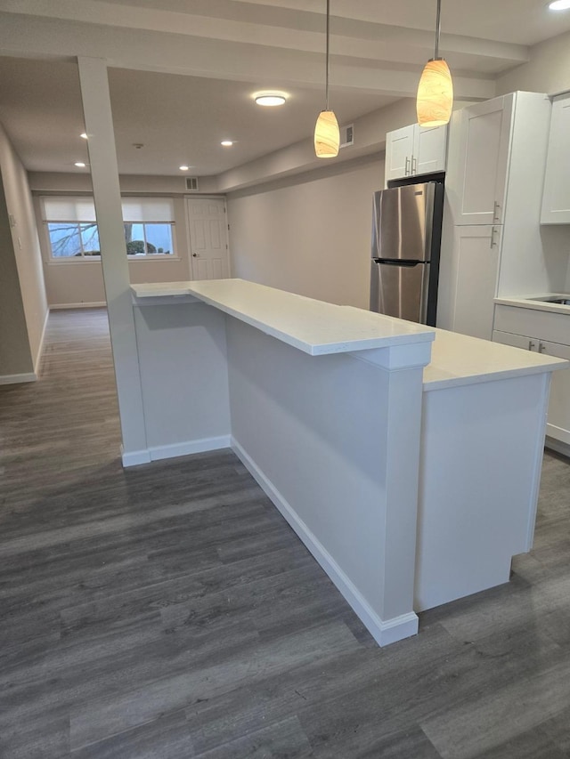 kitchen with light countertops, dark wood finished floors, freestanding refrigerator, and white cabinets