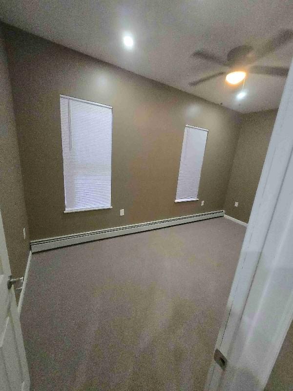 52 Lander St, Newburgh, NY 12550 - spare room featuring baseboard heating, ceiling fan, and baseboards