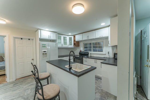 kitchen featuring black electric range, dark countertops, white cabinets, a sink, and white fridge with ice dispenser