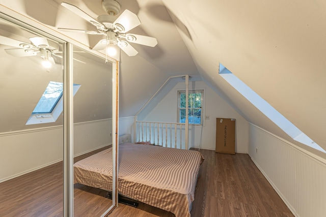 bedroom featuring lofted ceiling with skylight, ceiling fan, and wood finished floors