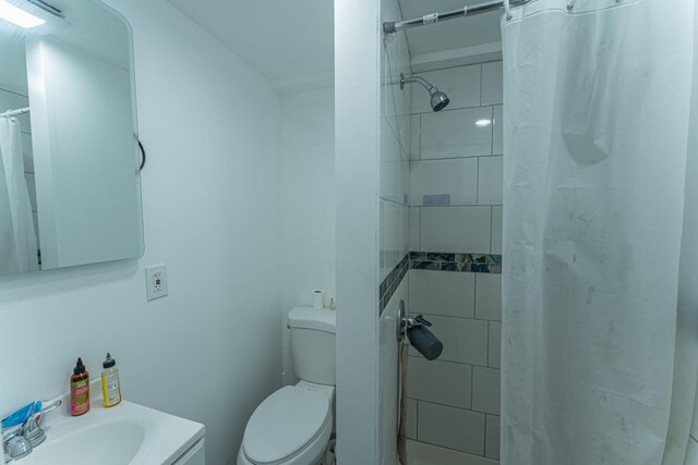 bathroom with curtained shower, a sink, and toilet