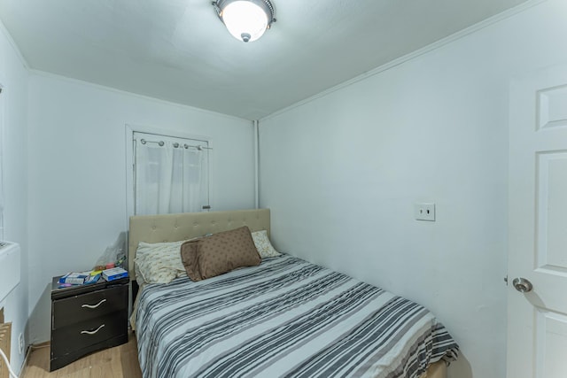 bedroom featuring ornamental molding and light wood-style floors