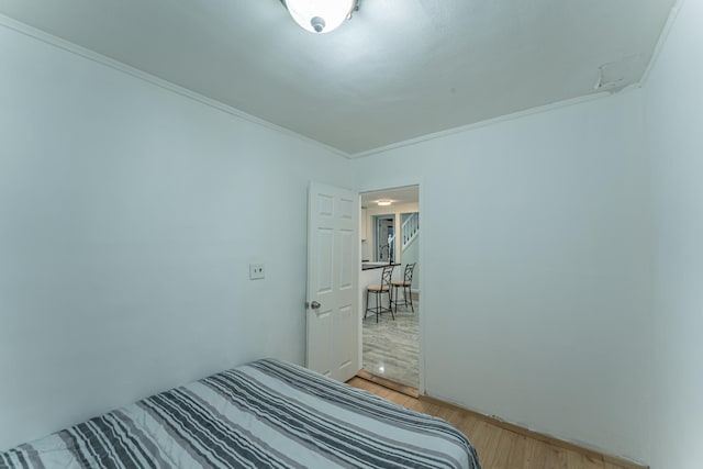 unfurnished bedroom featuring wood finished floors and crown molding