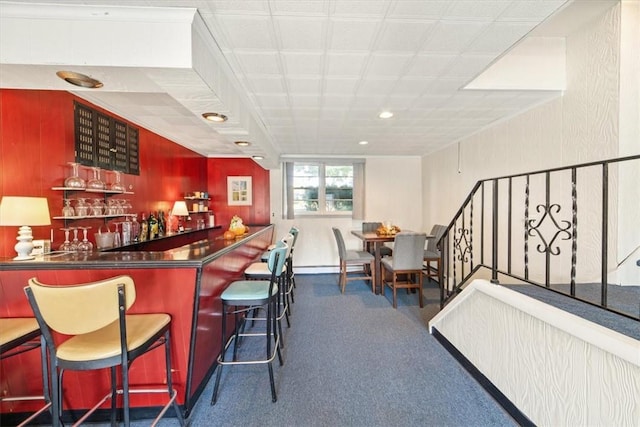 bar with carpet floors, recessed lighting, and a bar