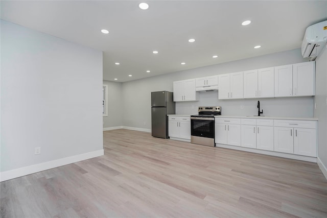 kitchen featuring baseboards, freestanding refrigerator, an AC wall unit, electric stove, and under cabinet range hood