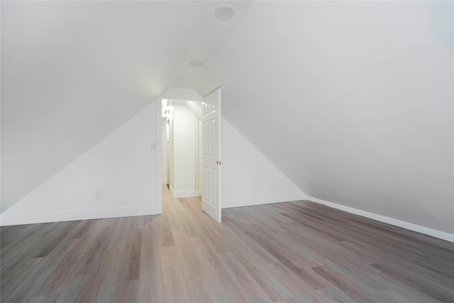 additional living space with lofted ceiling, baseboards, and wood finished floors